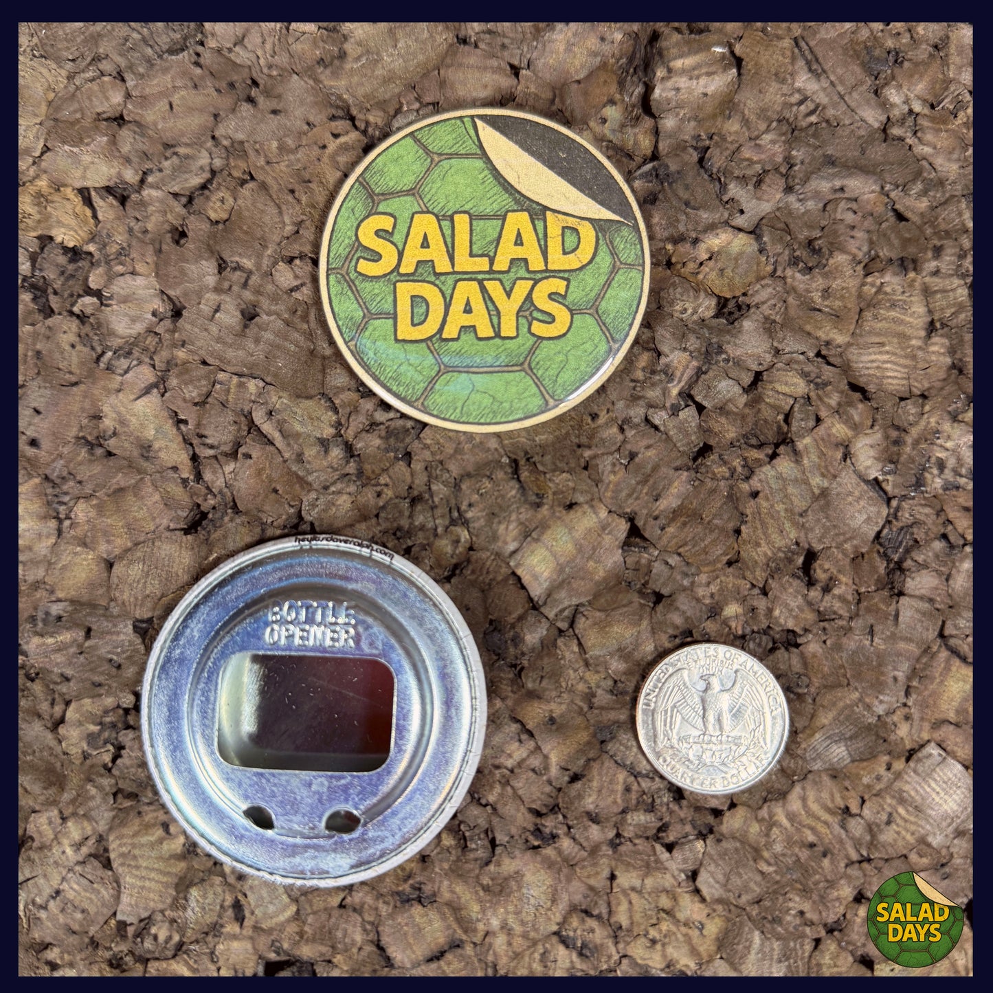 Two buttons on a textured surface, one labeled 'Salad Days' with a coin for scale showing the 2.25" bottle opener size.